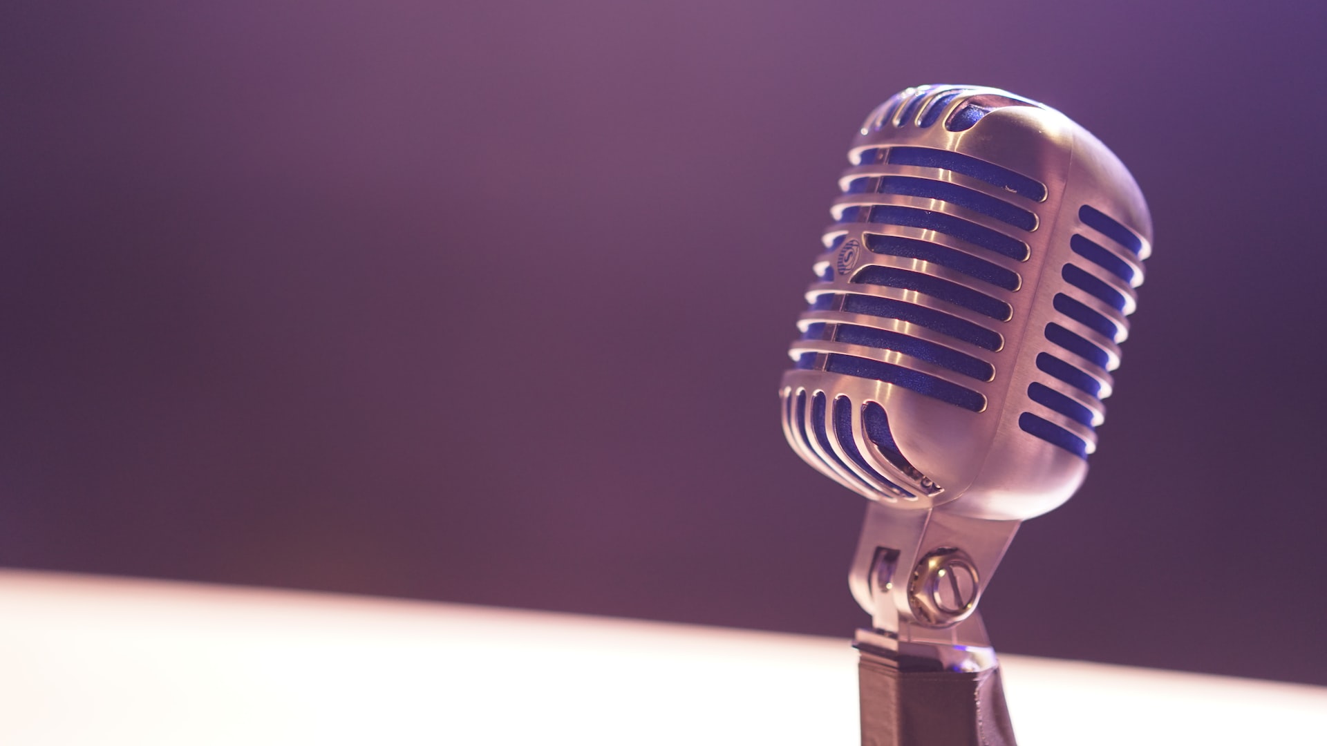 Close-up of a microphone against a purple background